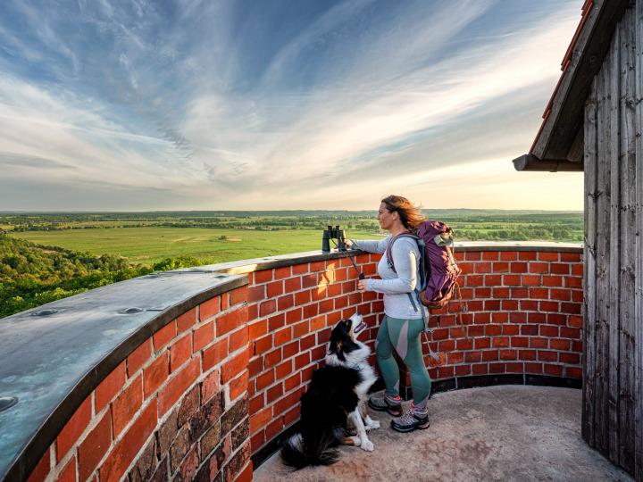 Eine Frau mit ihrem Hund genießt den Ausblick auf dem Bismarckturm © Bad Freienwalde Tourismus GmbH