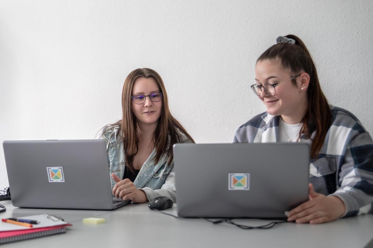 Zwei Jugendliche arbeiten an Laptops