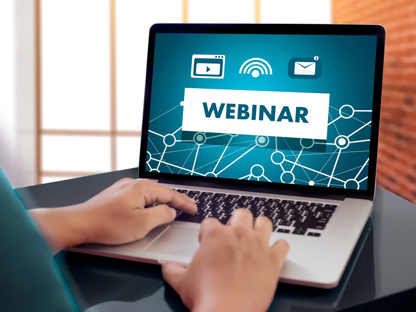 Eine Person sitzt am Laptop bei einem Webinar © juststock/iStock