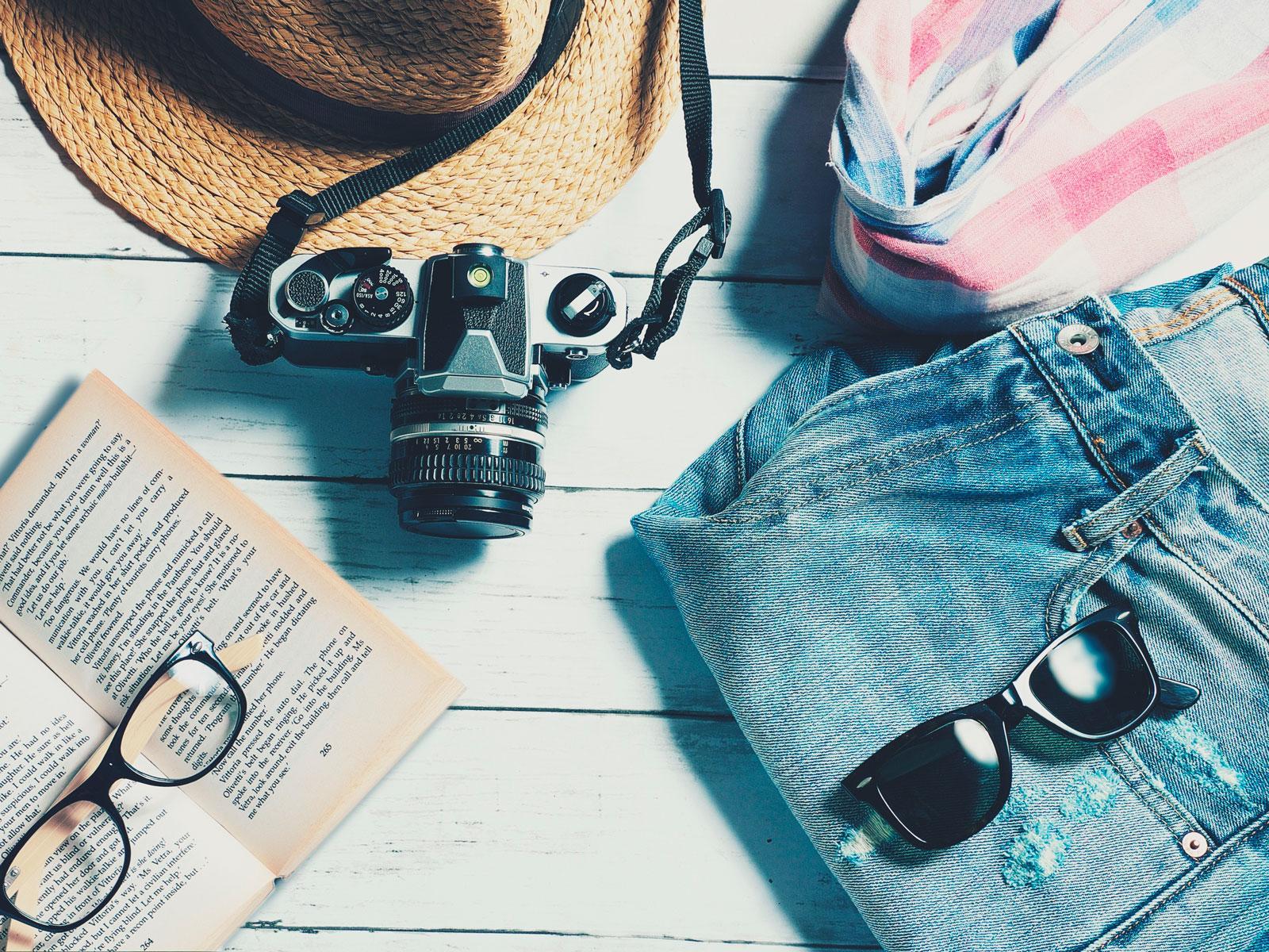 Kapelusz przeciwsłoneczny, okulary przeciwsłoneczne, dżinsy, książka i okulary do czytania © veerasantinithi/Pixabay