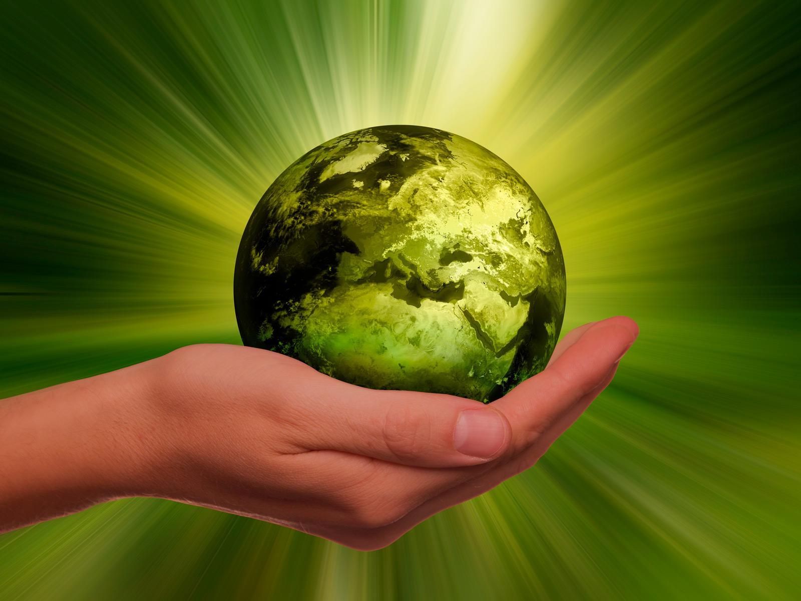 Ręka trzymająca zieloną, świecącą kulę ziemską © Gerd Altmann/Pixabay