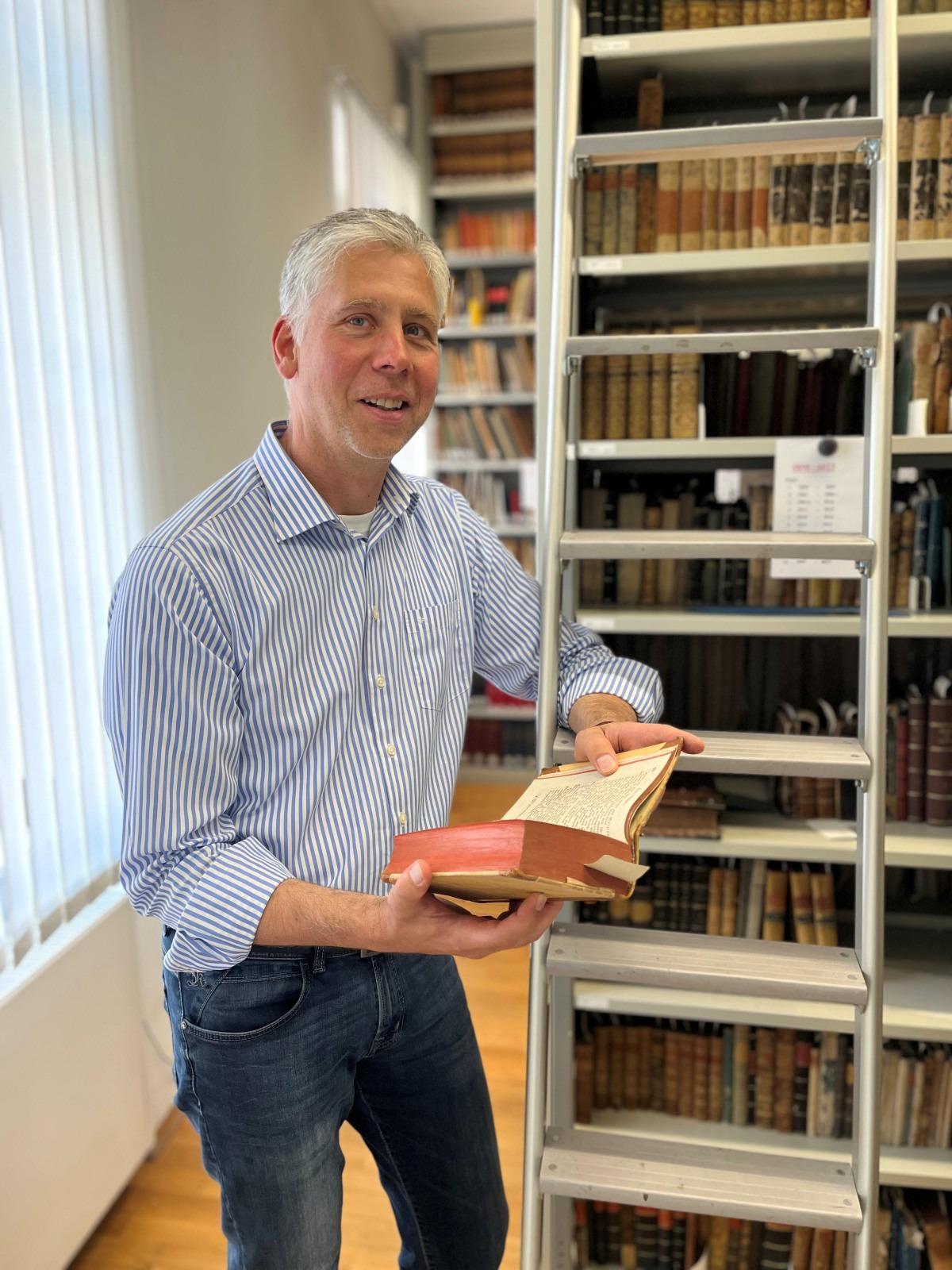: Neu am Museum Viadrina: Der Berliner Literaturwissenschaftler und Kurator Lutz Dittrich bearbeitet ein Forschungs- und Ausstellungsprojekt zur Frankfurter Literaturgeschichte. Das Foto zeigt ihn mit einem historischen Druck in der Museumsbibliothek. Foto: Tim S. Müller