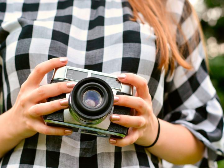 Eine Person hält eine Fotokamera © congerdesign/Pixabay