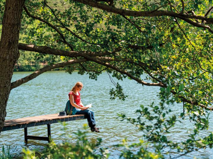 Lesende Frau im Sommer auf einem Steg am Wirchensee © Seenland Oder-Spree/Florian Läufer