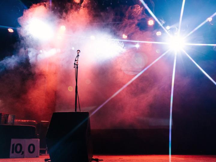 Ein Mikrofon auf einer Bühne mit Scheinwerferlicht und Nebel © Michelle Jekel
